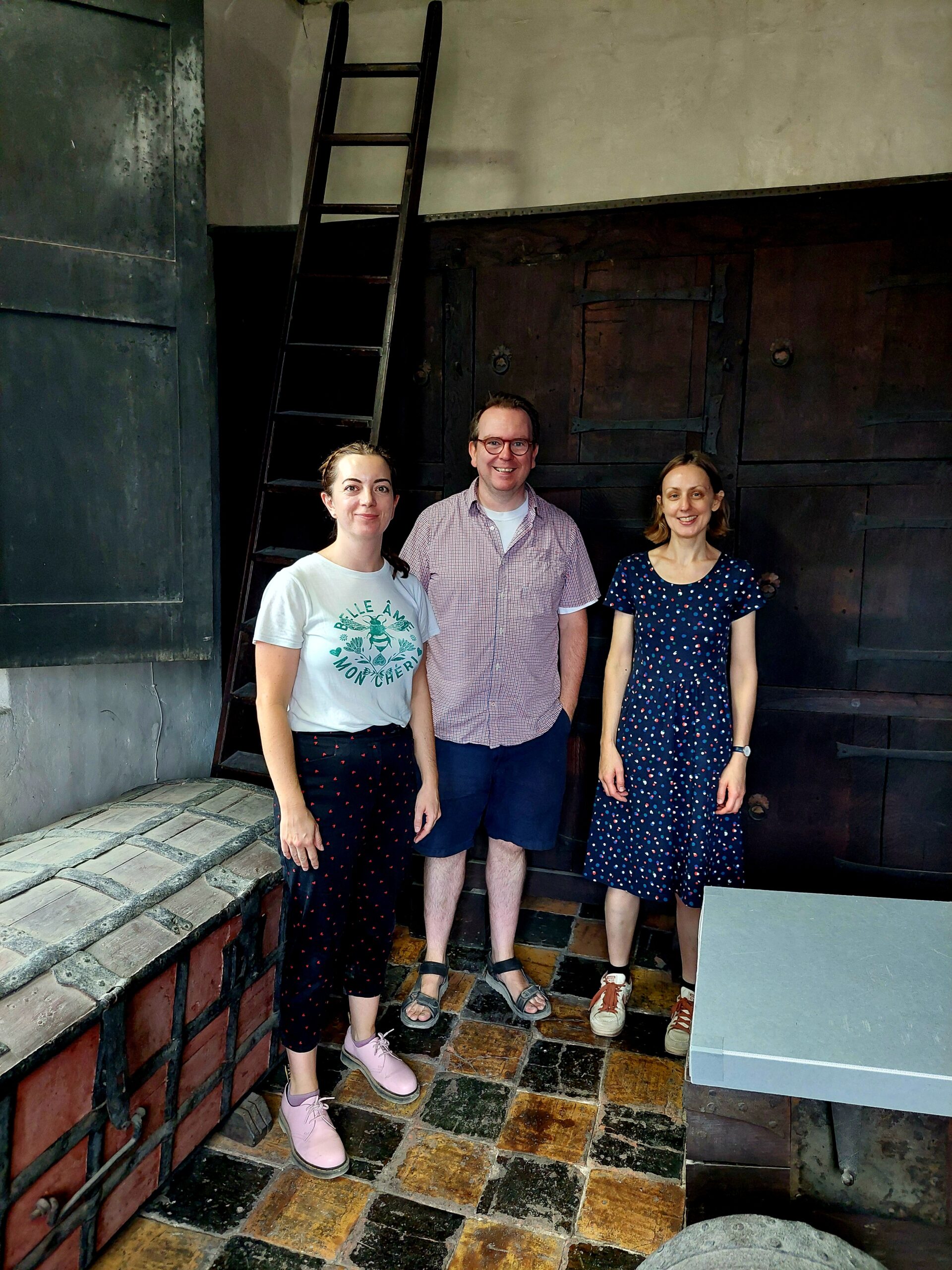 Colour photograph of Magdalen College archivists Richard Allen, Claudia Williams and Emily Jennings, posed in the Muniment Tower, 2025.