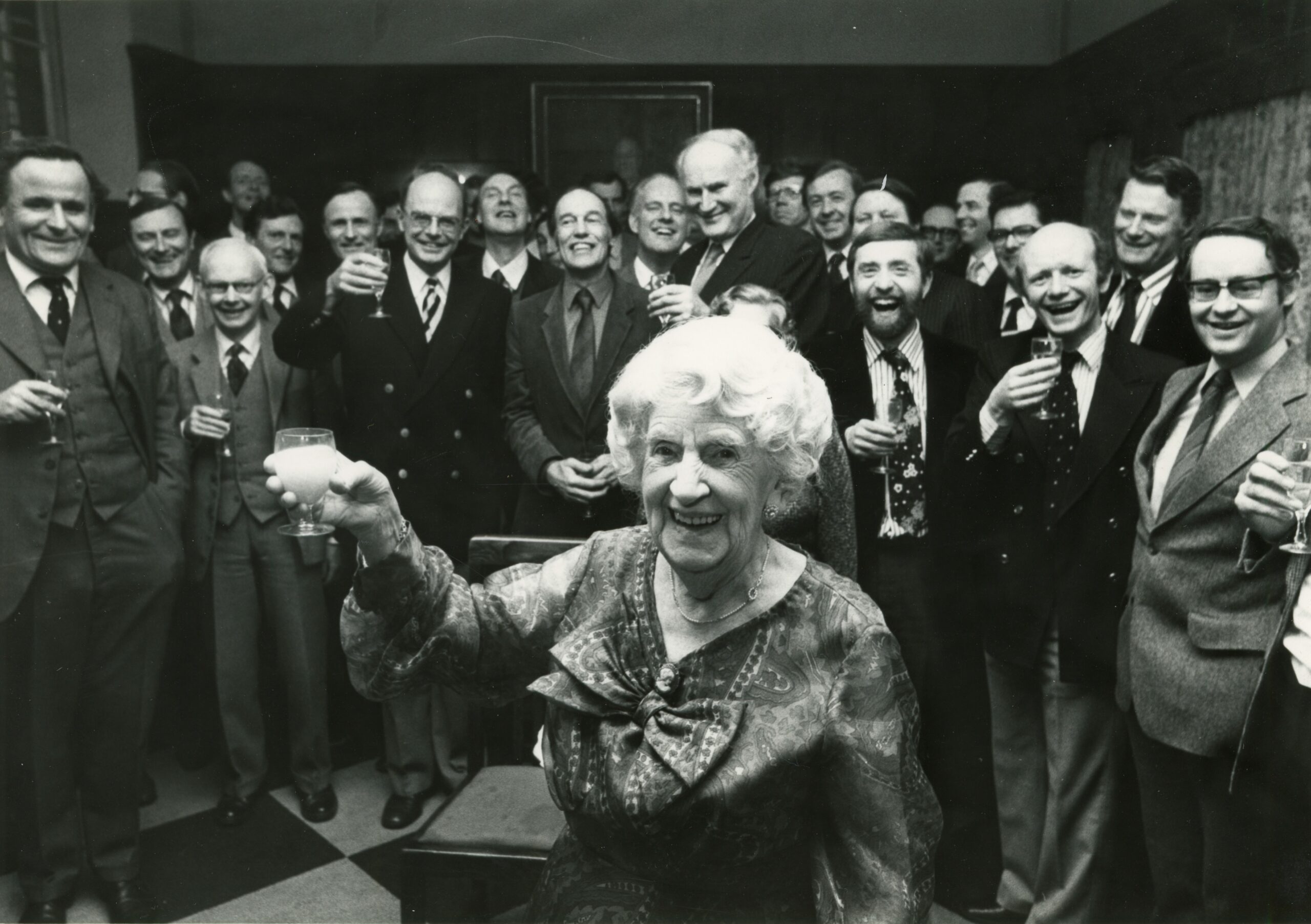 Black-and-white photograph of Eleanor Richardson, retired 159 Iffley Road landlady, with former tenants - all Magdalen alumni - on the occasion of her 100th birthday party in 1981.