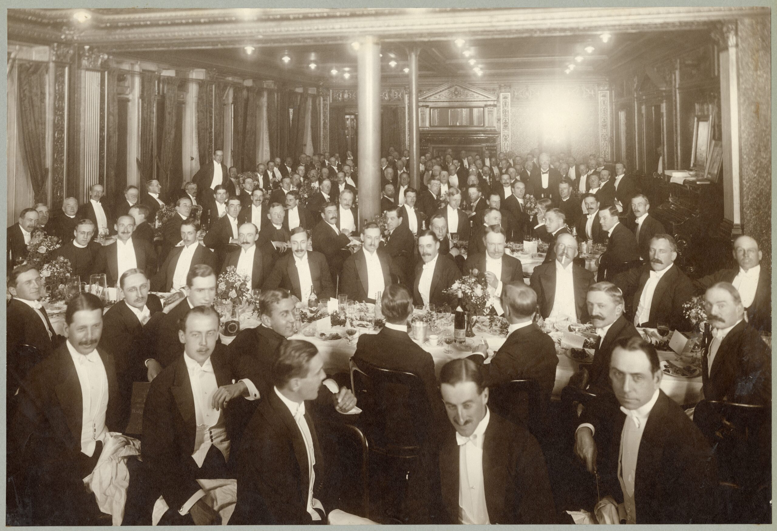Black-and-white photograph taken at a retirement dinner for Richard Gunstone, Magdalen College JCR Steward, on 6 July 1914. The guests are all wearing white tie.